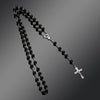 A black beaded rosary necklace featuring a vintage cross and Virgin Mary pendant.