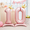 Pink foil number balloon '10' with gold crowns for a birthday celebration