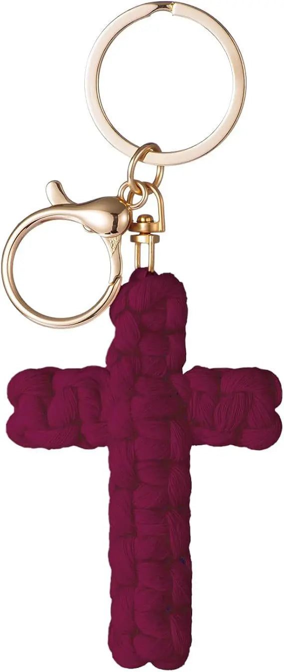 A deep magenta woven cross keychain with a gold-toned split ring and clasp.