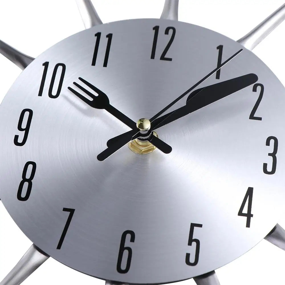 A silver modern cutlery 3D wall clock showing the time.