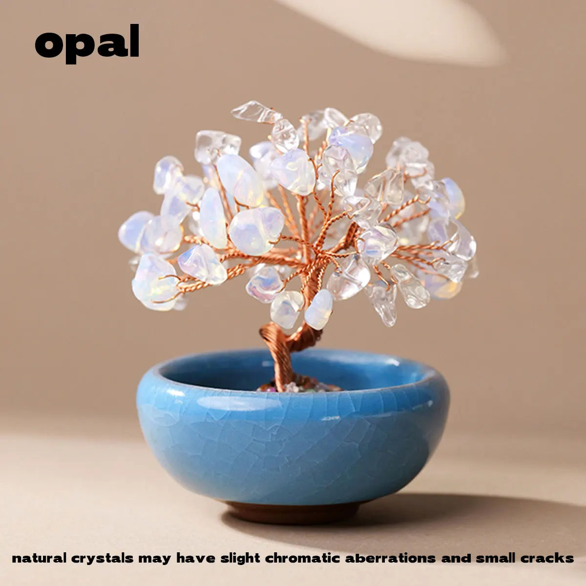 Handcrafted crystal tree with clear quartz crystals mounted on a copper wire base in a blue bowl.