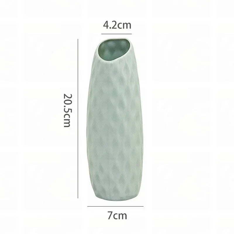 A tall, light green textured plastic vase with a narrow opening.