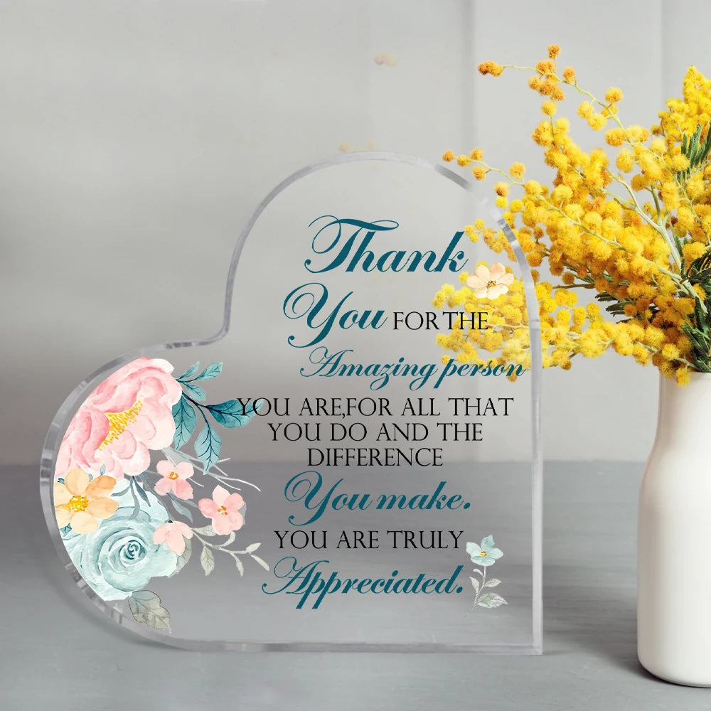 Clear acrylic heart-shaped sign with blue script saying Thank you for the amazing person you are and the difference you make.