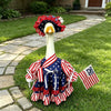 A white goose costume with red, white, and blue patriotic fabric accents lying on green grass.