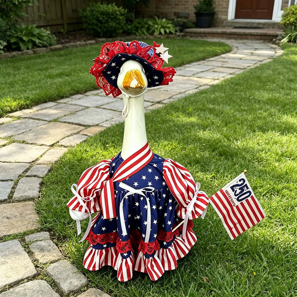 A white goose costume with red, white, and blue patriotic fabric accents lying on green grass.