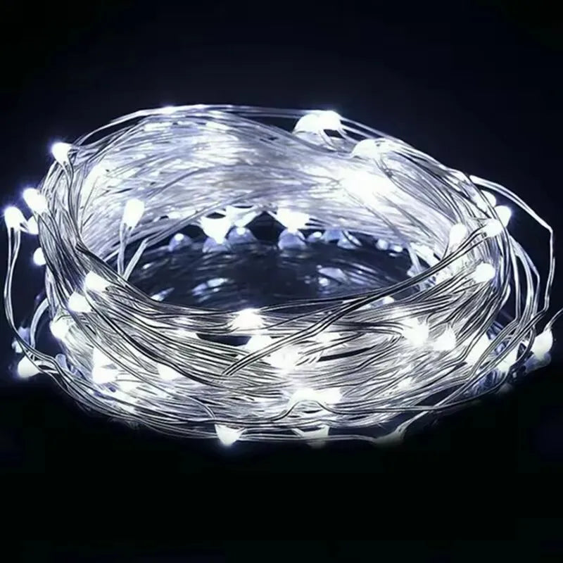 A bundle of bright white fairy string lights coiled against a dark background.