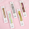 Pack of six curved metallic birthday candles in various shades of gold and green on white cards.