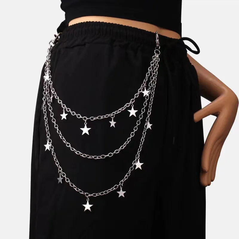 A close-up of a black garment featuring a layered silver chain necklace with star charms.