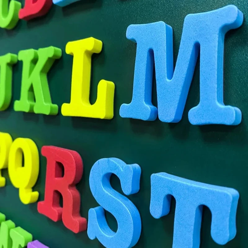 A collection of colorful magnetic alphabet letters spelling out words on a dark green surface.