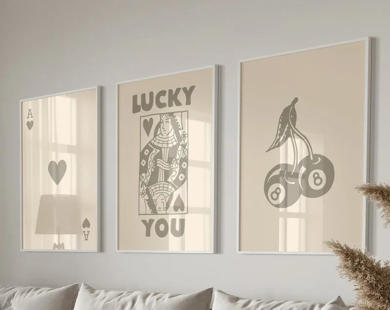 Three framed canvas prints featuring the text LUCKY YOU and a stylized silhouette of a bird and apples.