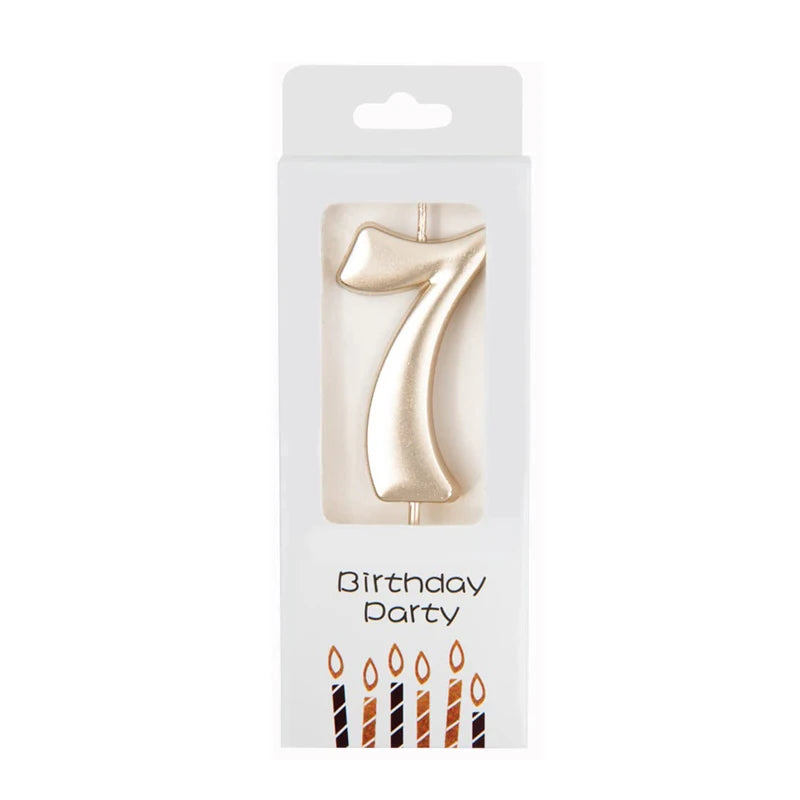 A gold number candle shaped like the number seven for birthday party decor.