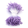 A cluster of purple artificial flower stamens with white filaments and a base for DIY decoration.