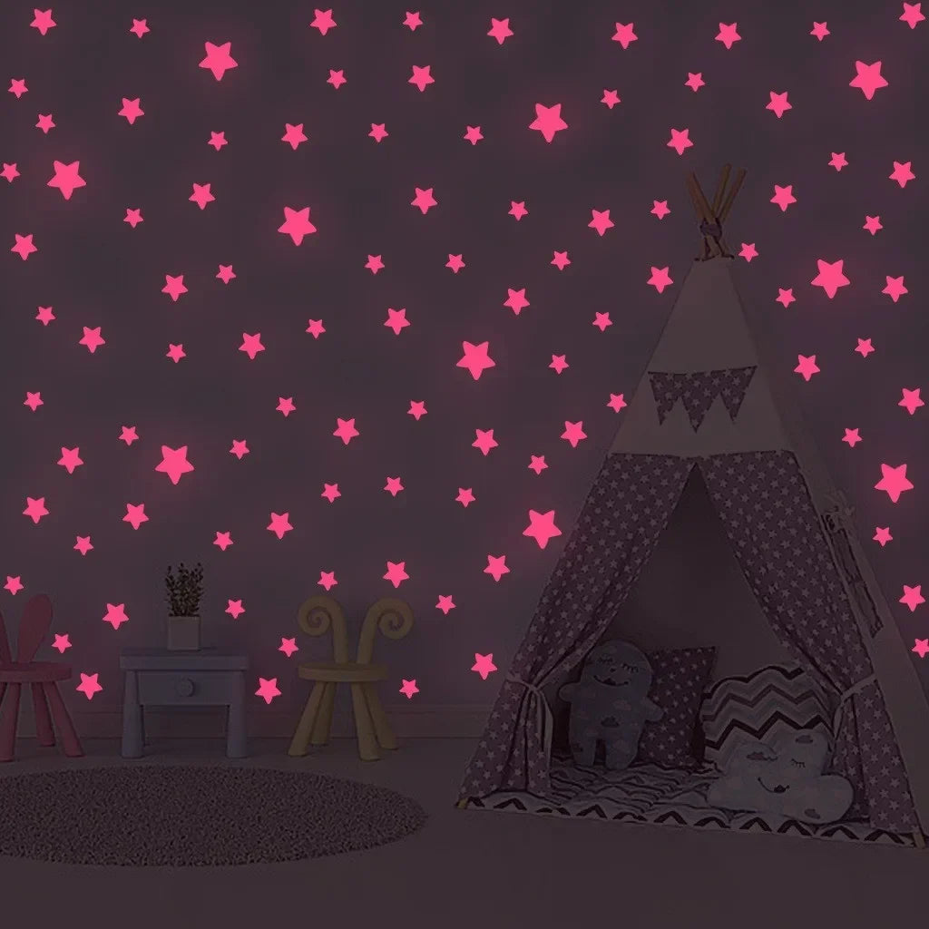A dark room decorated with pink glow-in-the-dark stars on the wall, featuring a tent structure and furniture.