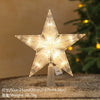 A sparkling LED Christmas tree star topper with a warm white glow displayed on a surface.