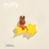 A small, round brown bunny magnet with a yellow star attached on a light background.