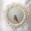Miroir macramé rond à bordure géométrique frangée, affiché sur fond blanc.