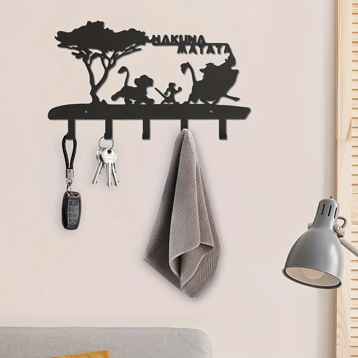 Black metal key hooks and a decorative silhouette of a monkey on a wall
