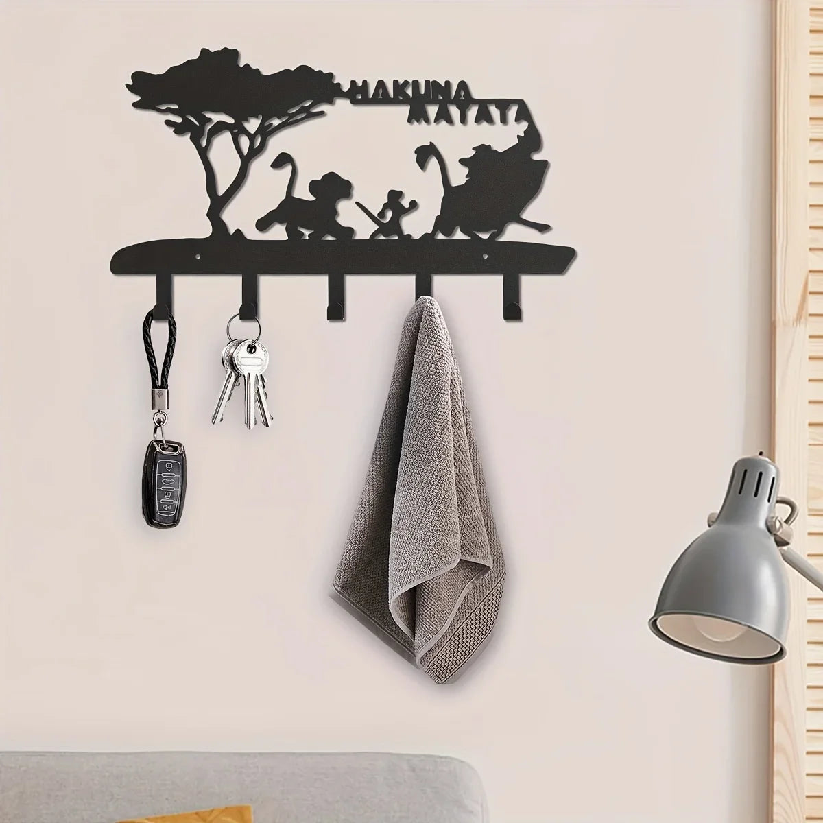 Black metal key hooks with a silhouette of a monkey and text on a wall