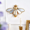 Gold resin animal wall hanging decor featuring a dragonfly design mounted on a white wall.