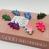 A collection of articulated baby dragon figurines in various shades of blue, green, and pink displayed on a brown box.