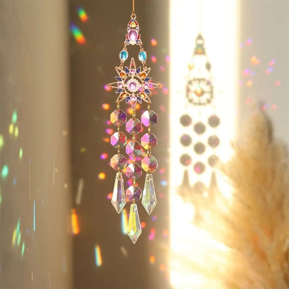 A hanging crystal suncatcher wind chime ornament with pink and purple crystals catching sunlight.