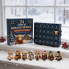 A box of a 24-day advent calendar with Highland cow figurines and a grid of numbered boxes on a windowsill covered in snow.