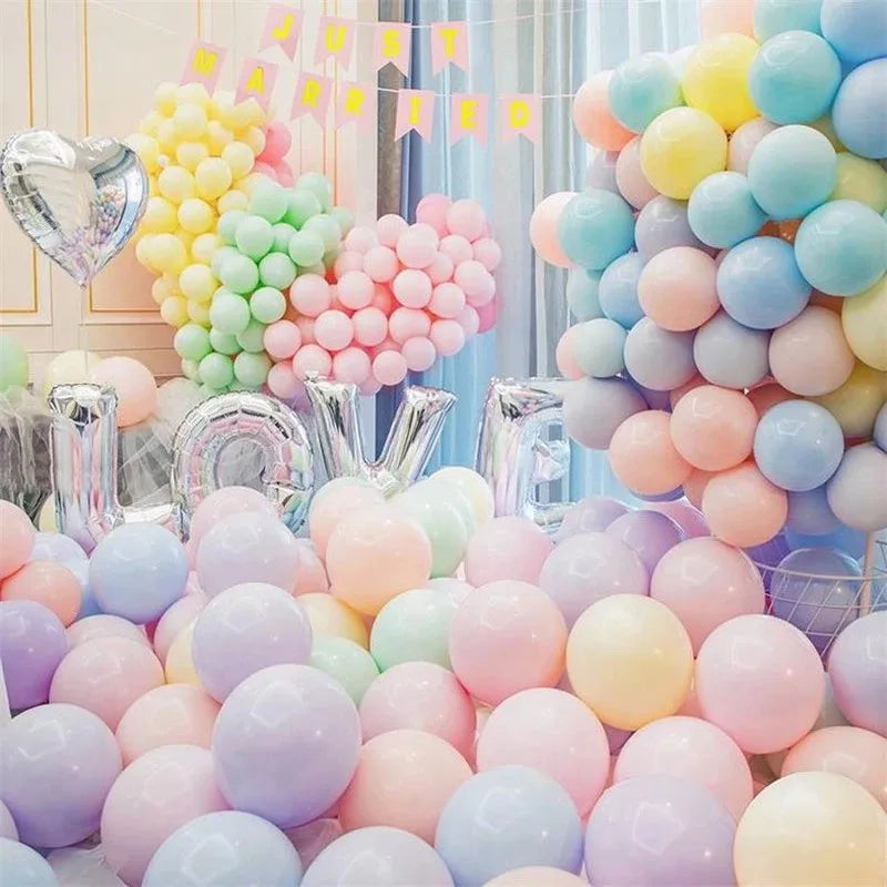 A large arrangement of pastel macaron balloons in assorted rainbow colors, including pink, yellow, green, and blue.