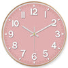 A pink round wall clock with white numbers and hands displaying the time.