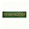 A rectangular, distressed green metal tin sign with the words WAR ROOM written in gold lettering.