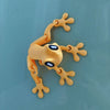 A yellow, movable 3D printed tree frog ornament with outstretched limbs against a light blue background.