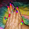A hand displays various neon fluorescent colored nail polish or pigment powders on the fingernails.