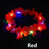A red LED flower crown headband with glowing lights against a dark background.