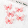 Pink embroidered butterfly patches with sparkling accents on white lace fabric