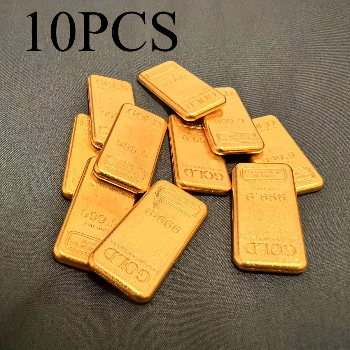 A set of ten simulated gold ingot fortune charms arranged on a dark surface.