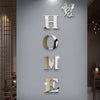 Silver acrylic wall stickers spelling out HOME with a butterfly design on a gray wall.