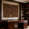 A leopard print tapestry wall hanging displayed in a traditional room with dark wood furniture and built-in bookshelves.