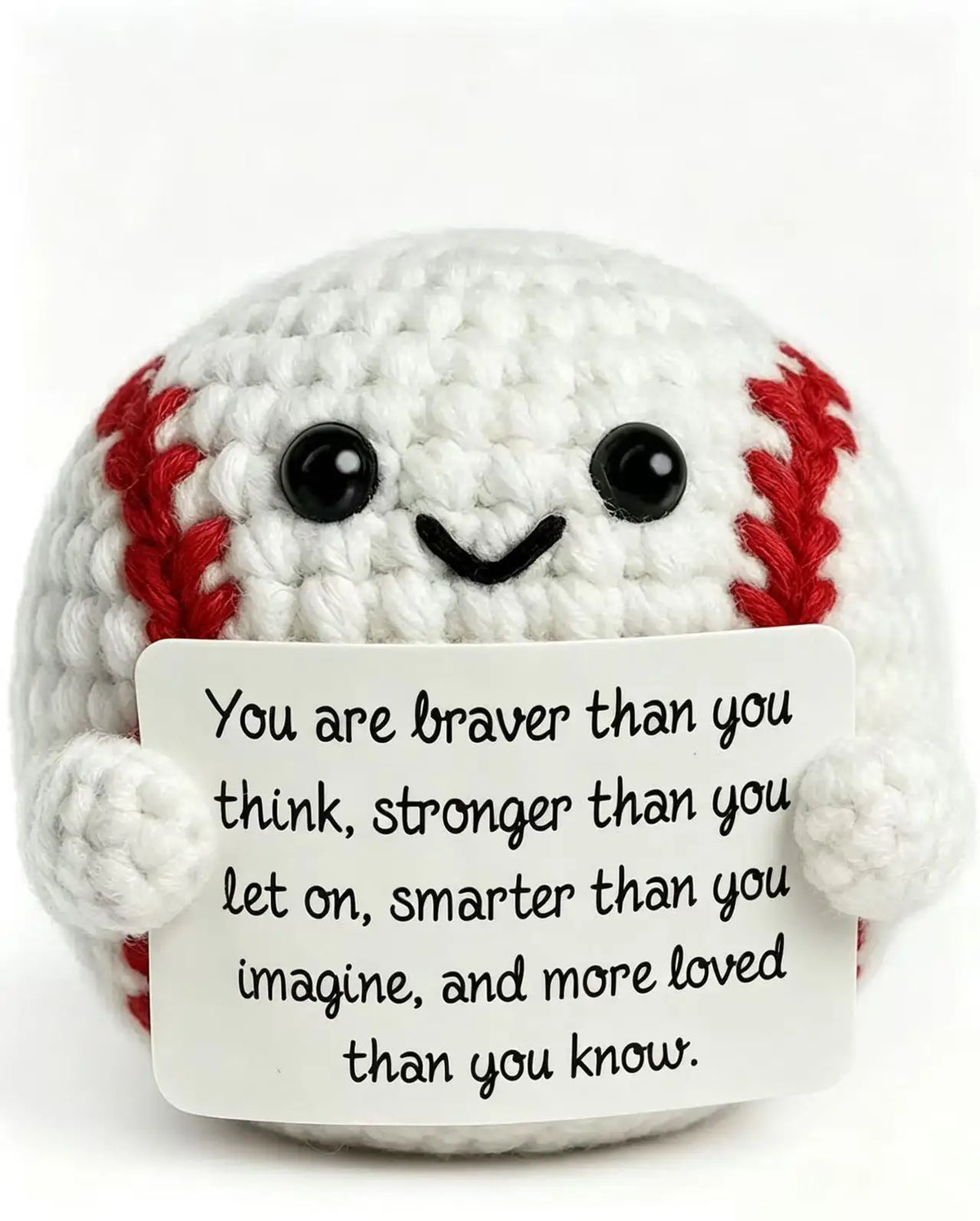 A handmade white crochet baseball bat doll with red stitching and a card that reads You are braver than you think stronger th