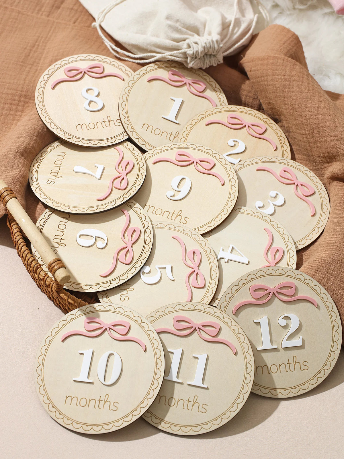 A collection of wooden baby milestone cards showing numbers 1 through 12 for monthly photo props