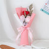 A pink handcrafted soap rose bouquet wrapped in sheer pink paper and tied with a ribbon.