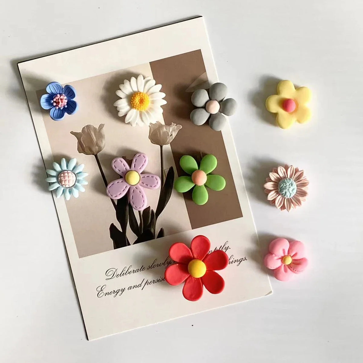 A photo message card featuring various colorful flower magnets on a neutral background.