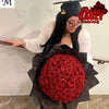 A woman holds a bouquet of red artificial roses in black wrapping for DIY crafts and gifting.