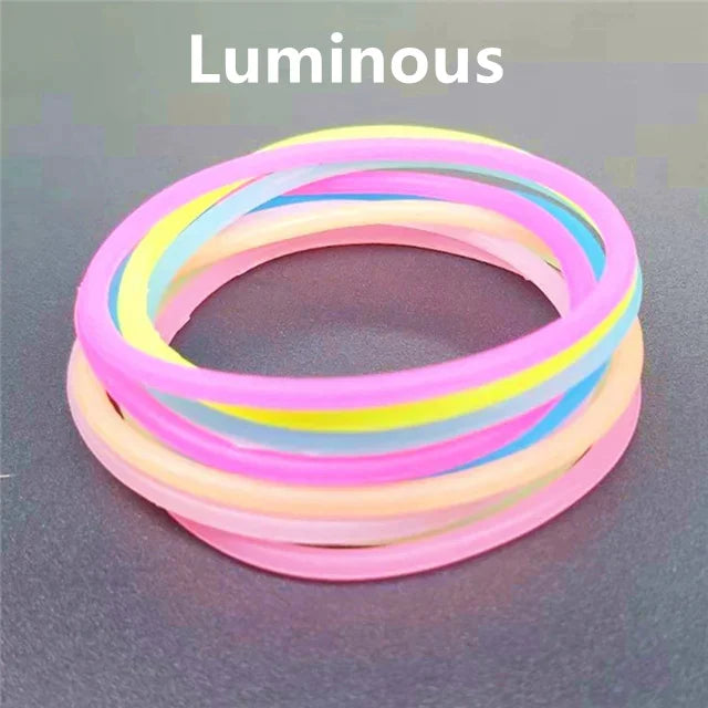 A set of ten luminous silicone bracelets in various pastel colors, including pink, yellow, and blue.
