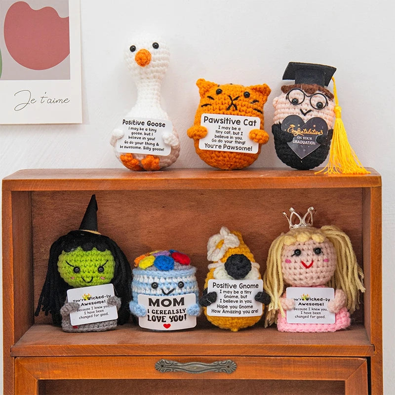 A collection of handmade crochet positive potato dolls featuring inspirational slogans and pocket hugs.