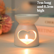 A white ceramic essential oil diffuser and candle burner with a heart-shaped glow.