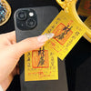 A hand holds a gold wealth amulet phone sticker next to a golden object.