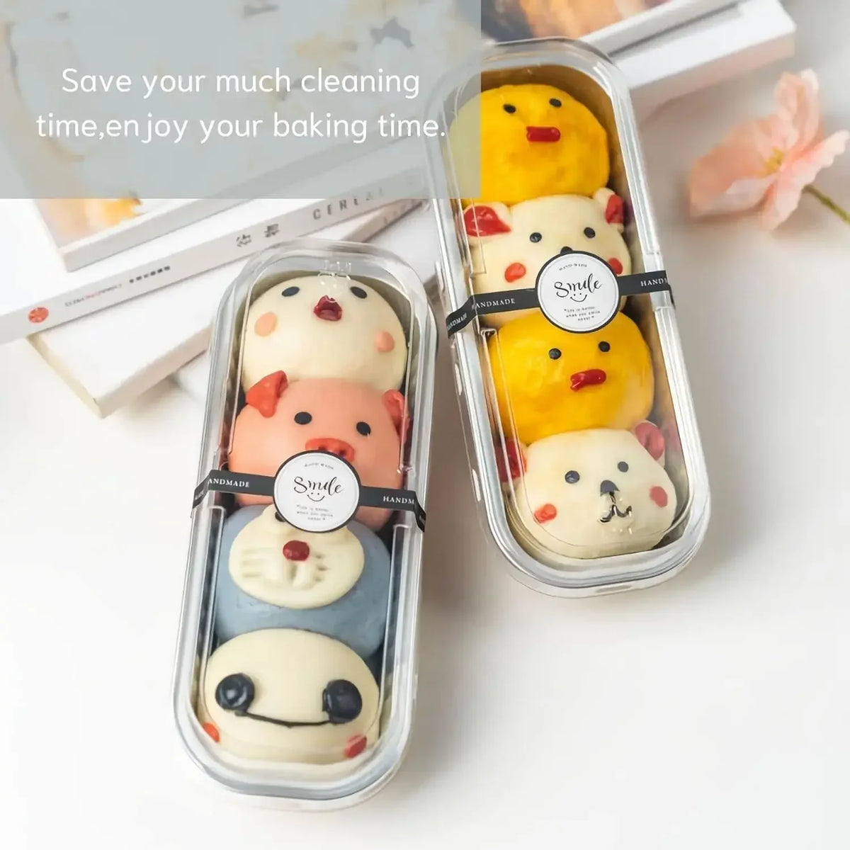 A set of mini foil bread trays with lids containing various shaped baked goods like yellow and pink buns.