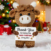 A handmade crochet brown cow doll with white accents holding a card that reads Thank You for being the moo-tivation in my lif