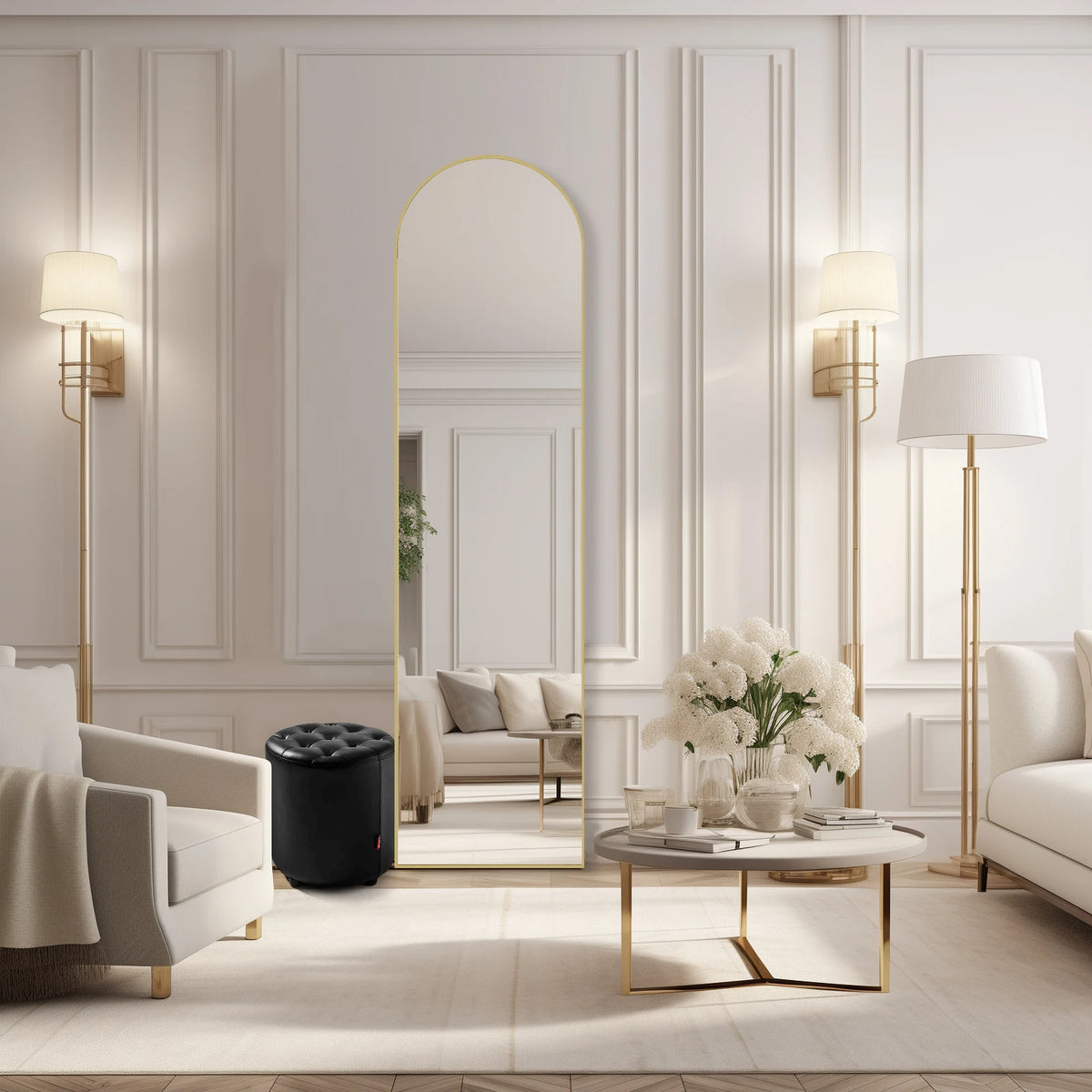 A full length arched gold mirror hangs on a white wall in a bright, elegant living room setting.