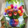 A bouquet of colorful tulips in a glass pot hangs, acting as a sun catcher ornament.