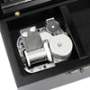 A hand-cranked wooden music box mechanism with a silver cylinder and metal components inside a black box.